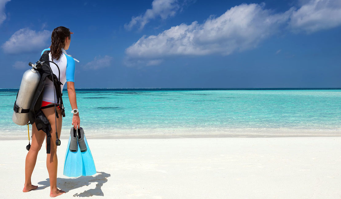 Person in scuba gear standing on the beach