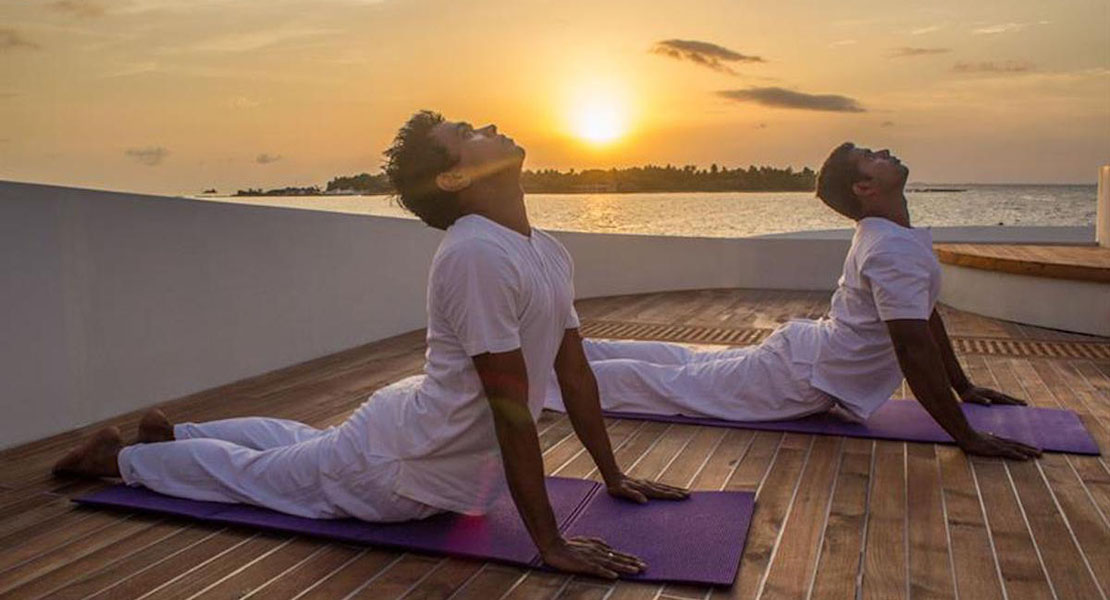 Two people performing yoga exercise on a boat